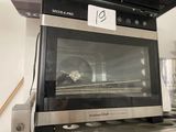 a black and silver oven sitting on top of a stove