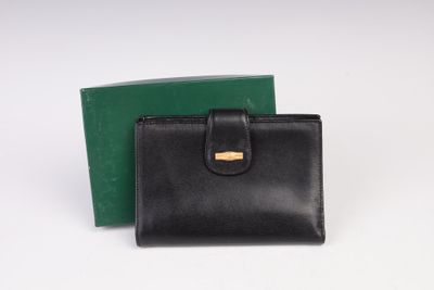 un portefeuille en cuir noir avec un fermoir doré et une boîte verte
