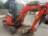 a small red excavator that is parked in a parking lot