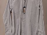 a white and grey shirt hanging on a hanger on a wall