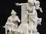 an antique figurine of a man and a woman on a pedestal