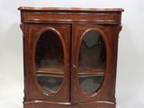une vieille armoire en bois surmontée de deux portes vitrées