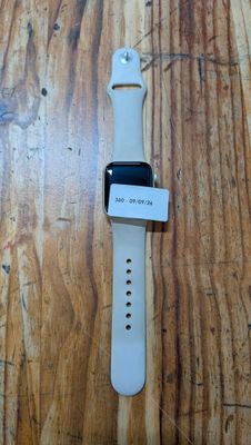 une Apple Watch posée sur un parquet, à côté d'une table en bois