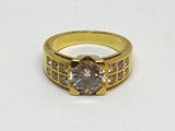 gros plan d'une bague en or avec un diamant au centre