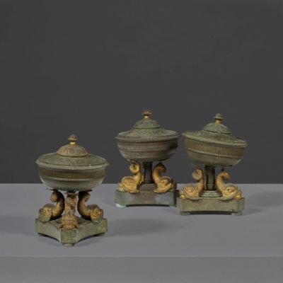 three bronze figurines of birds on pedestals on a table
