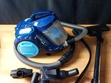 un aspirateur bleu posé sur une table en bois