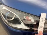 a person holding up a sticker to a car ' s headlight