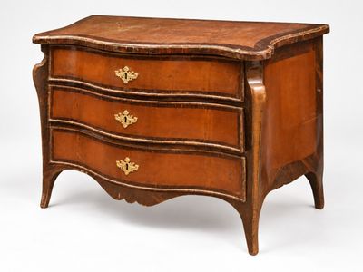 une commode ancienne avec un plateau en bois et des ferrures en laiton