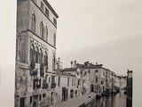 black and white photograph of a canal and buildings in an old town