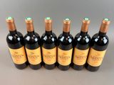 six bottles of red wine lined up in a row