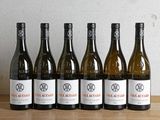 six bouteilles de vin sont alignées sur une table en bois