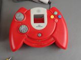 a red game console with a game controller attached to it
