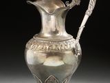an image of a silver vase with a handle on a table