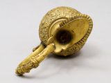 a small brass pipe with a handle on a white surface