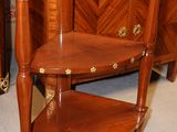 a corner table with a shelf on it in a room