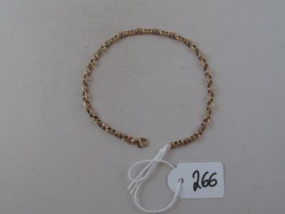 bracelet with gold beads and a tag on a white surface