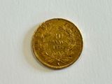 a gold coin that is sitting on a white surface