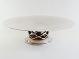a white plate with a silver base on a white table