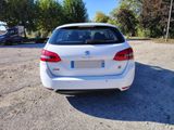 the back end of a white car parked in a parking lot
