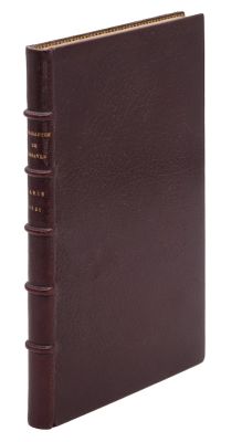 un livre en cuir marron surmonté d'une reliure dorée