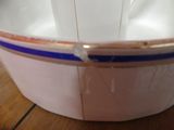 a white bowl with blue trim on a wooden table