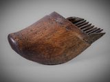 an old wooden shoe brush with a wooden handle on a gray background
