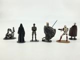 star wars figurines sit on a white surface with a white background