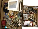 a box full of assorted jewelry on a white surface