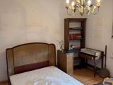 a bedroom with a bed, desk, and a chandelier