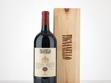 a bottle of wine sitting next to a wooden box on a table