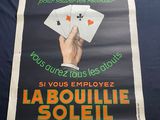 a poster of a hand holding playing cards on a table