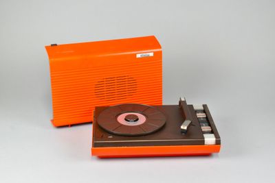 un tourne-disque orange à côté d'une radio orange, posés sur une surface blanche