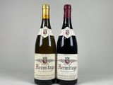 two bottles of wine sitting next to each other on a table