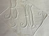 a white pillow with a monogram on it