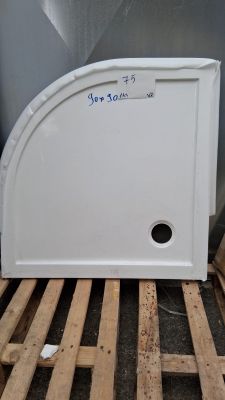 un réfrigérateur blanc posé sur une palette contre un mur