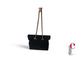 un sac noir auquel est suspendue une chaîne dorée par la poignée