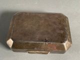 a small metal box with a lid on a table