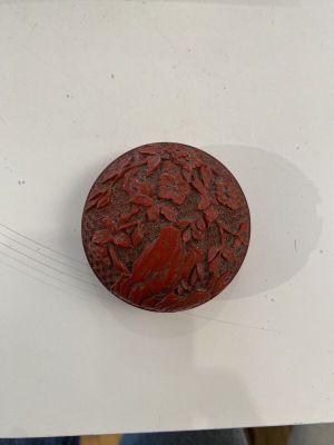 un petit objet rouge posé sur une surface blanche, sur une table