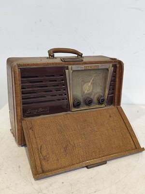 une valise marron contenant une radio, posée sur une table