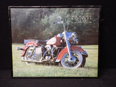 une photo d'une moto rouge garée dans l'herbe
