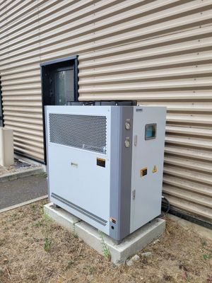 un climatiseur installé à l'extérieur d'un immeuble, à côté d'un autre immeuble