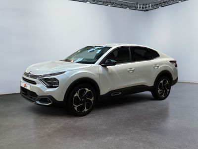 the white suv is parked in a large room with white walls