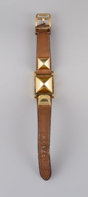 un bracelet de montre en cuir marron orné de pyramides dorées