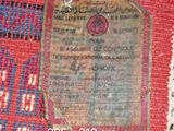 a piece of paper on a rug with a tag attached to it