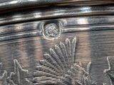 a close up of a silver plate with a design on it