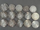six quarters of silver coins are arranged in a row on a gray surface