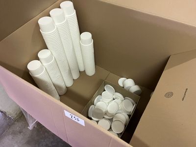 de nombreuses tasses, les unes à côté des autres, dans une boîte en carton posée par terre