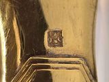 a close up of a gold colored object on a white surface