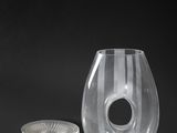 a glass vase and a coin on a black background