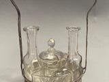 a silver and glass teapot with a handle on a table